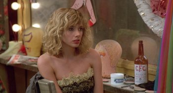 Movie still from “Desperately Seeking Susan” (1985), directed by Susan Seidelman – A woman sitting at a table in front of a mirror; Close Up shot, Over the shoulder angle