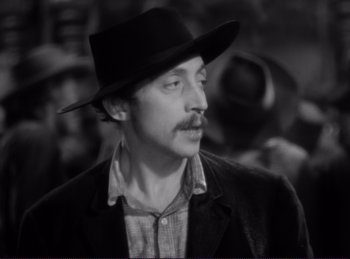 Movie still from “Destry Rides Again” (1939), directed by George Marshall – A man in a black hat and a jacket; Close Up shot, High angle