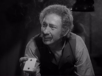 Movie still from “Destry Rides Again” (1939), directed by George Marshall – An older man holding a deck of playing cards; Close Up shot, High angle