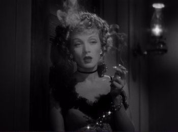Movie still from “Destry Rides Again” (1939), directed by George Marshall – A black and white photo of a woman smoking a cigarette; Close Up shot, Low angle