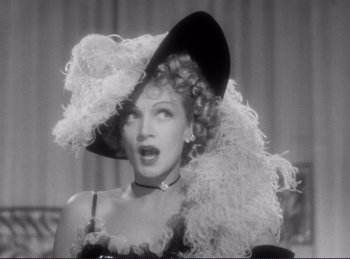 Movie still from “Destry Rides Again” (1939), directed by George Marshall – A black and white photo of a woman wearing a hat; Close Up shot, Low angle