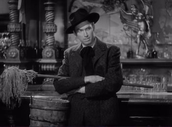 Movie still from “Destry Rides Again” (1939), directed by George Marshall – A black and white photo of a man in a suit and hat; Medium shot, Low angle