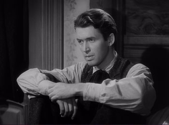 Movie still from “Destry Rides Again” (1939), directed by George Marshall – Black and white photograph of a man sitting in a chair; Close Up shot, High angle