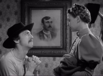 Movie still from “Destry Rides Again” (1939), directed by George Marshall – A man and a woman in front of a painting; Medium shot, Over the shoulder angle