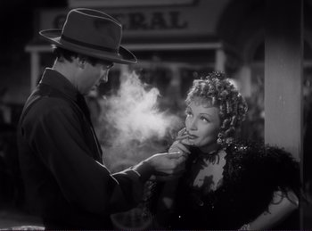 Movie still from “Destry Rides Again” (1939), directed by George Marshall – A man and a woman are smoking a cigarette together; Medium shot, Over the shoulder angle
