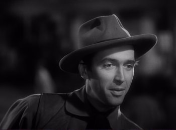 Movie still from “Destry Rides Again” (1939), directed by George Marshall – A black and white photo of a man wearing a hat; Close Up shot, Over the shoulder angle
