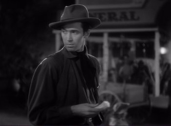 Movie still from “Destry Rides Again” (1939), directed by George Marshall – A black and white photo of a man in a hat; Medium shot, Over the shoulder angle