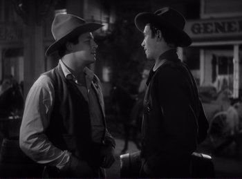 Movie still from “Destry Rides Again” (1939), directed by George Marshall – A couple of men standing next to each other; Medium shot, Over the shoulder angle