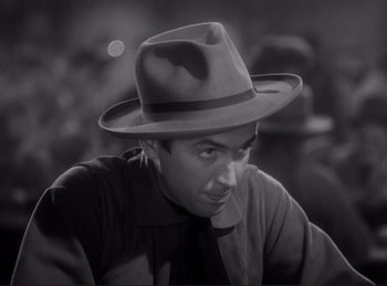 Movie still from “Destry Rides Again” (1939), directed by George Marshall – A black and white photo of a man wearing a hat; Close Up shot, High angle