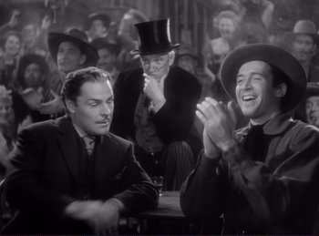 Movie still from “Destry Rides Again” (1939), directed by George Marshall – A group of men sitting around a table; Medium shot, Over the shoulder angle