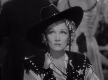 Movie still from “Destry Rides Again” (1939), directed by George Marshall – A black and white photo of a woman wearing a cowboy hat; Close Up shot, Low angle