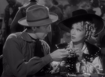 Movie still from “Destry Rides Again” (1939), directed by George Marshall – A man and a woman are holding hands; Medium shot, High angle