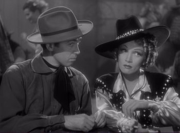 Movie still from “Destry Rides Again” (1939), directed by George Marshall – A man and a woman wearing hats and a tie; Medium shot, Over the shoulder angle