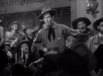 Movie still from “Destry Rides Again” (1939), directed by George Marshall – A black and white photo of a man in a crowd; Medium shot, Low angle
