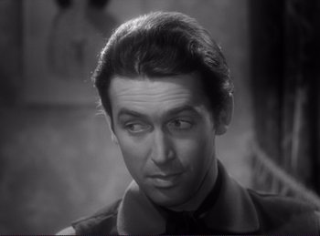 Movie still from “Destry Rides Again” (1939), directed by George Marshall – A black - and - white photo of a man in a suit and tie; Close Up shot, Over the shoulder angle