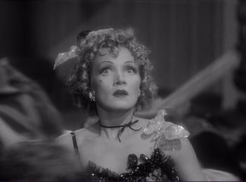 Movie still from “Destry Rides Again” (1939), directed by George Marshall – An old black and white photo of a woman in a dress; Close Up shot, Low angle