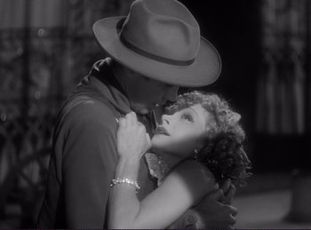 Movie still from “Destry Rides Again” (1939), directed by George Marshall – A man and a woman embracing each other in a black and white photo; Close Up shot, High angle