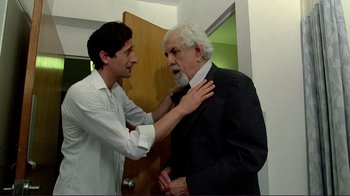Movie still from “Detachment” (2011), directed by Tony Kaye – An older man adjusting a younger man's tie; Medium shot, Over the shoulder angle