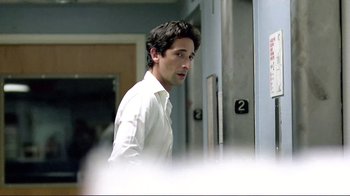 Movie still from “Detachment” (2011), directed by Tony Kaye – A man in a white dress shirt is looking at the camera; Close Up shot, Over the shoulder angle