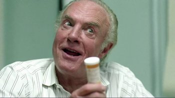 Movie still from “Detachment” (2011), directed by Tony Kaye – An older man holding a pill bottle in his hand; Close Up shot, Low angle