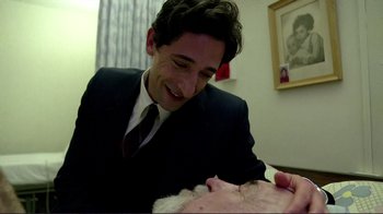 Movie still from “Detachment” (2011), directed by Tony Kaye – A man in a suit and tie smiling at a woman in a suit; Medium shot, Over the shoulder angle
