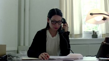 Movie still from “Detachment” (2011), directed by Tony Kaye – A woman sitting at a desk talking on a phone; Close Up shot, High angle