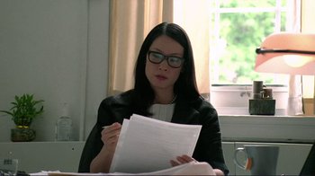 Movie still from “Detachment” (2011), directed by Tony Kaye – A woman sitting at a table with papers in front of a window; Close Up shot, Over the shoulder angle