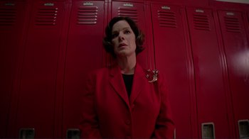 Movie still from “Detachment” (2011), directed by Tony Kaye – A woman in a red suit standing in front of lockers; Medium shot, Low angle