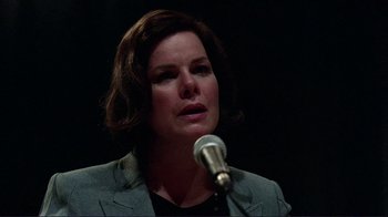 Movie still from “Detachment” (2011), directed by Tony Kaye – A woman is speaking into a microphone in front of a black background; Close Up shot, Low angle