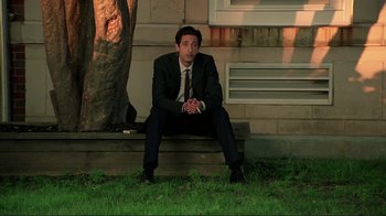 Movie still from “Detachment” (2011), directed by Tony Kaye – A man in a suit and tie sitting on a bench; Medium shot, High angle