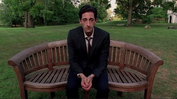 Movie still from “Detachment” (2011), directed by Tony Kaye – A man in a suit sitting on top of a wooden bench; Medium shot, High angle