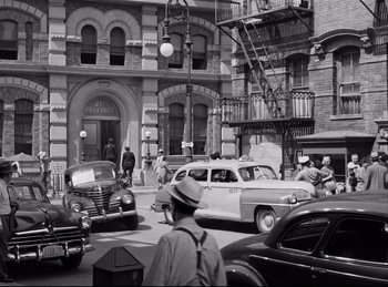Movie still from “Detective Story” (1951), directed by William Wyler – An old photo of a busy city street with many cars; Extreme Wide shot, High angle