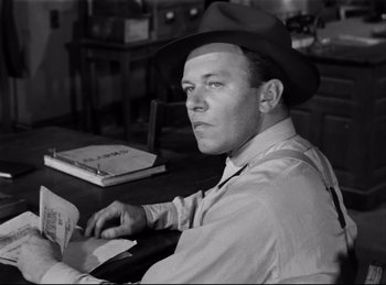Movie still from “Detective Story” (1951), directed by William Wyler – A black and white photo of a man wearing a hat; Medium shot, Low angle