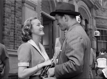 Movie still from “Detective Story” (1951), directed by William Wyler – A man and a woman standing next to each other; Medium shot, Low angle