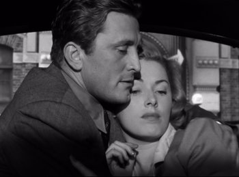 Movie still from “Detective Story” (1951), directed by William Wyler – A black and white photo of a man and a woman in the backseat of a car; Close Up shot, Low angle