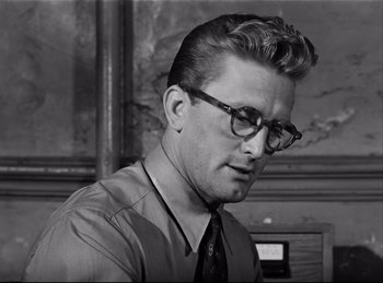 Movie still from “Detective Story” (1951), directed by William Wyler – A man in a suit and tie looking down; Close Up shot, Low angle