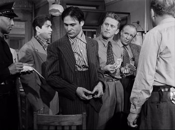 Movie still from “Detective Story” (1951), directed by William Wyler – A black and white photo of a group of men in suits; Medium shot, Low angle