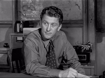Movie still from “Detective Story” (1951), directed by William Wyler – A man sitting at a desk in front of a computer; Close Up shot, Low angle