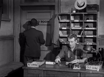 Movie still from “Detective Story” (1951), directed by William Wyler – An old photo of two men working at a store; Medium shot, Low angle
