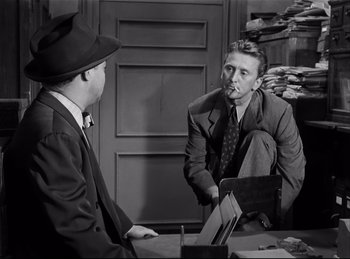 Movie still from “Detective Story” (1951), directed by William Wyler – Two men sitting at a table talking to each other; Medium shot, Over the shoulder angle