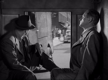 Movie still from “Detective Story” (1951), directed by William Wyler – Two men sitting on a bus talking to each other; Medium shot, Low angle