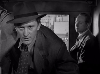 Movie still from “Detective Story” (1951), directed by William Wyler – A black and white photo of a man in a suit and tie; Close Up shot, Low angle