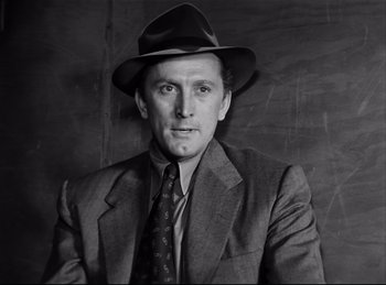 Movie still from “Detective Story” (1951), directed by William Wyler – A man wearing a suit and a hat; Close Up shot, Low angle