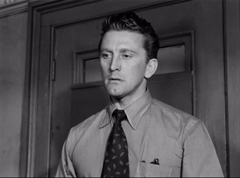 Movie still from “Detective Story” (1951), directed by William Wyler – Black and white photograph of a man wearing a tie; Close Up shot, Low angle