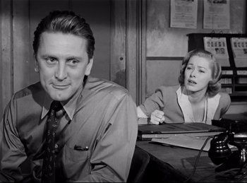 Movie still from “Detective Story” (1951), directed by William Wyler – A black and white photo of a man and a woman; Medium shot, Low angle