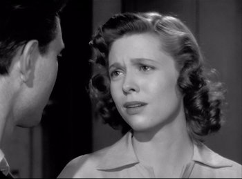 Movie still from “Detective Story” (1951), directed by William Wyler – An old photo of a young woman looking at a man; Close Up shot, Over the shoulder angle