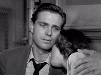 Movie still from “Detective Story” (1951), directed by William Wyler – A man and a woman embracing each other in a black and white photo; Close Up shot, Over the shoulder angle