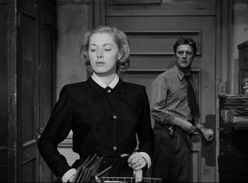 Movie still from “Detective Story” (1951), directed by William Wyler – A man and a woman standing next to each other in front of a door; Medium shot, Low angle