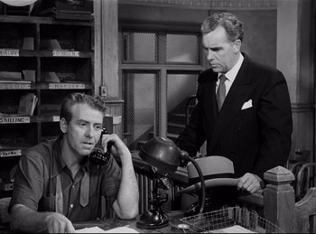 Movie still from “Detective Story” (1951), directed by William Wyler – Two men in suits and ties sitting at a desk; Medium shot, Low angle