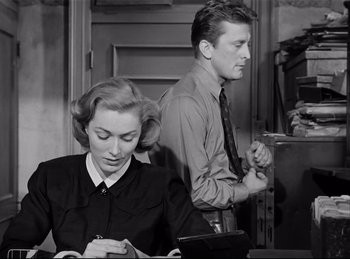 Movie still from “Detective Story” (1951), directed by William Wyler – A man and a woman are writing on a piece of paper; Medium shot, Low angle